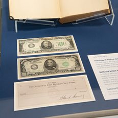 High denomination US currencies on view alongside check signed by JFK and autographed first copy of the first edition of "Security Analysis"