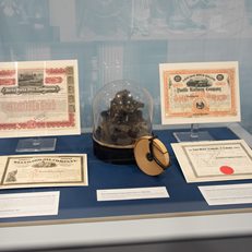 Stock ticker exhibited alongside certificates bearing famous signatures