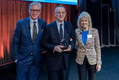Emcees Bob Pisani (left) and Consuelo Mack (right) present Howard Marks with the 2024 MoAF Lifetime Achievement Award.  Photographer: Alan Barnett