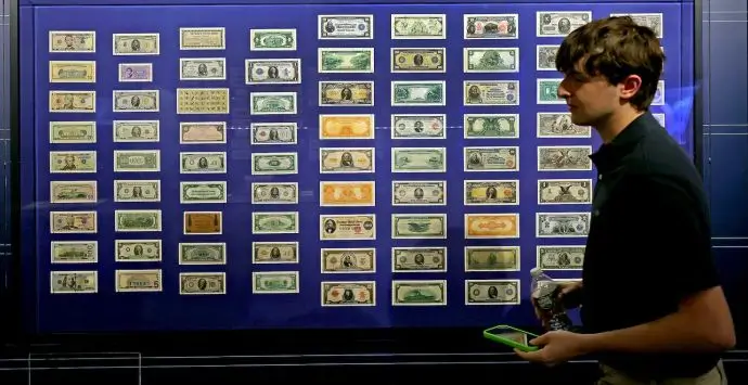 Jack Higgins of Portland, Oregon, passed a wall of money at the Museum of American Finance. David L. Ryan/Globe Staff