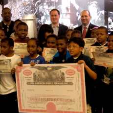 Students from PS 66 in Brooklyn show off their stock certificates.